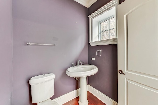 half bathroom featuring baseboards, toilet, and wood finished floors