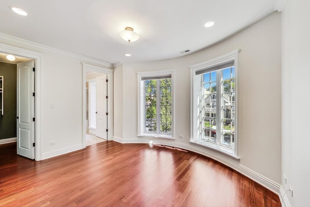 empty room featuring wood finished floors, baseboards, and recessed lighting