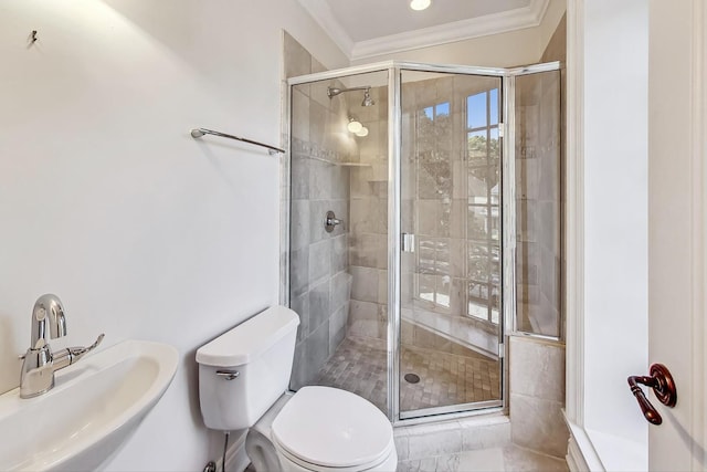 bathroom with a sink, a shower stall, crown molding, and toilet