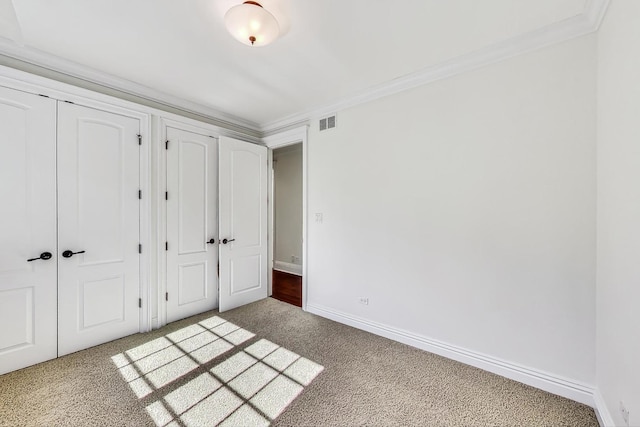 unfurnished bedroom featuring carpet flooring, baseboards, and crown molding