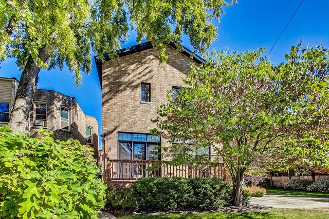 view of front of property with brick siding and fence