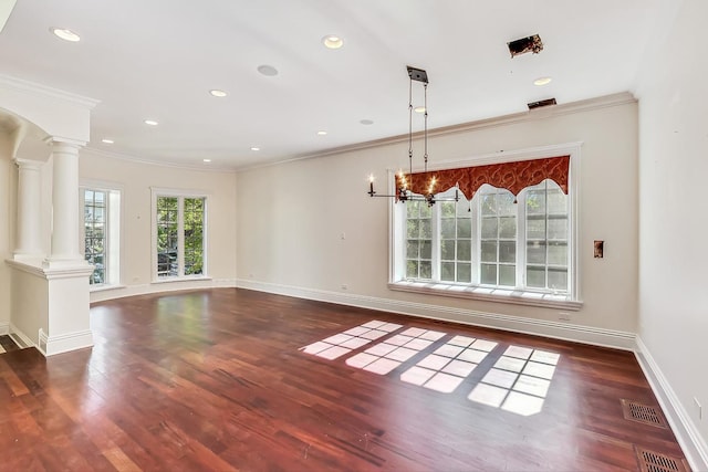 unfurnished dining area with ornate columns, wood finished floors, crown molding, baseboards, and recessed lighting