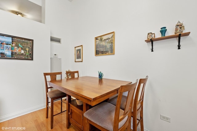 dining space with light wood-style floors, visible vents, and baseboards