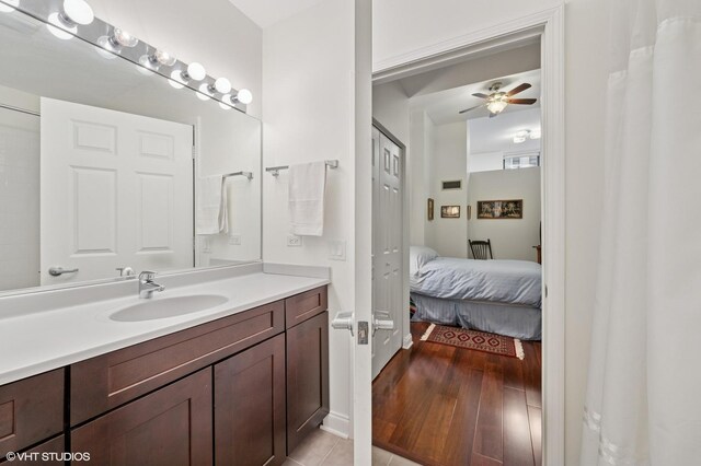 bathroom with ceiling fan, wood finished floors, connected bathroom, and vanity