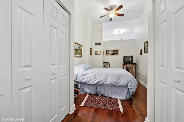 bedroom with a closet, baseboards, ceiling fan, visible vents, and wood finished floors