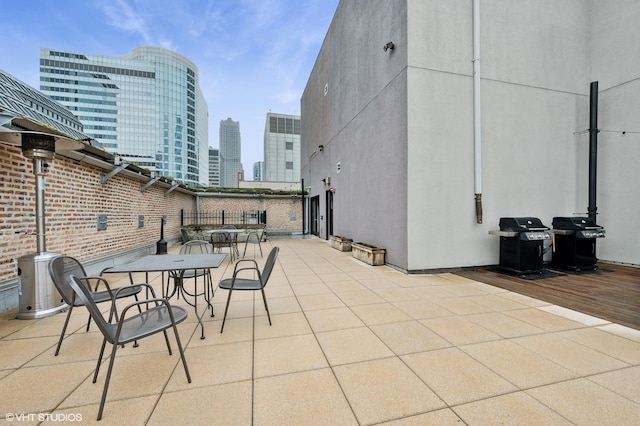 view of patio / terrace with area for grilling, outdoor dining area, and a view of city