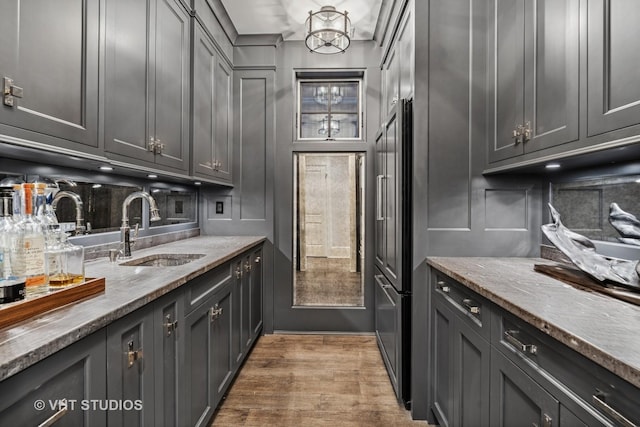 2140 N Seminary Ave, Chicago, IL 60614 - kitchen featuring wood finished floors, a sink, a chandelier, gray cabinetry, and light stone countertops