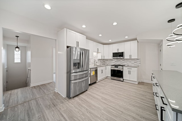 4616 N Kostner Ave, Chicago, IL 60630 - kitchen with tasteful backsplash, light stone counters, light wood-style floors, appliances with stainless steel finishes, and a sink