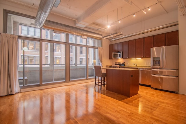 565 W Quincy St Unit 510, Chicago, IL 60661 - kitchen with a breakfast bar, light countertops, light wood-style floors, a center island, and appliances with stainless steel finishes