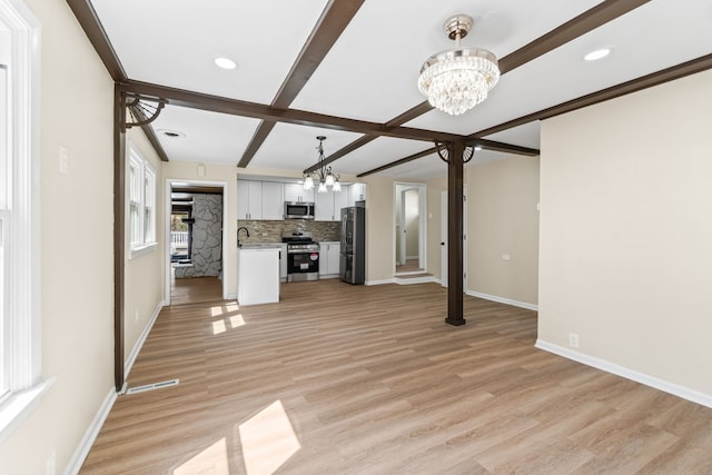 7730 Virginia Ct, Willowbrook, IL 60527 - unfurnished living room featuring a chandelier, baseboards, and light wood-style flooring