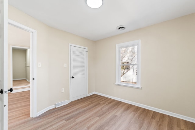 7730 Virginia Ct, Willowbrook, IL 60527 - unfurnished bedroom featuring visible vents, baseboards, a closet, and light wood-style floors