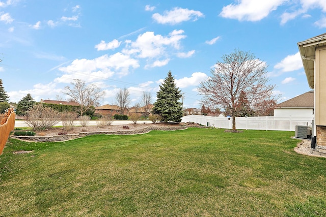 view of yard featuring fence and central AC unit