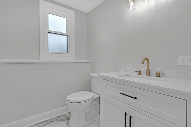 bathroom with marble finish floor, vanity, baseboards, and toilet