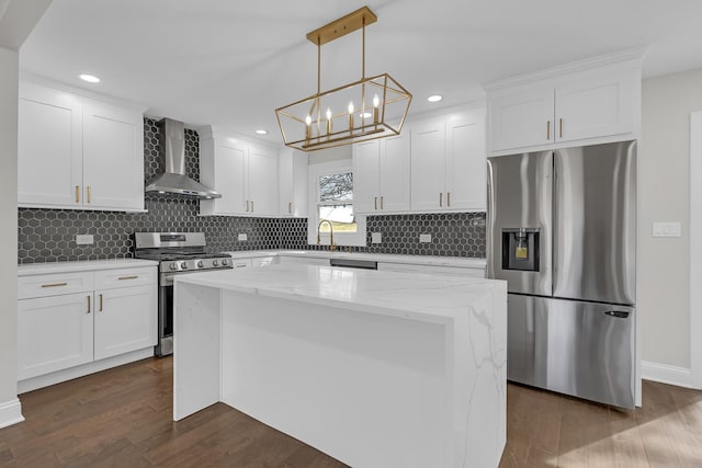 kitchen featuring wall chimney range hood, dark wood-style floors, white cabinetry, stainless steel appliances, and a kitchen island