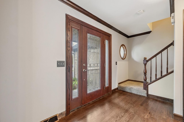 entrance foyer featuring stairway, ornamental molding, wood finished floors, plenty of natural light, and baseboards