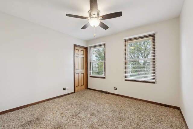 carpeted spare room with baseboards and ceiling fan