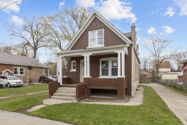 7521 S Parnell Ave, Chicago, IL 60620 - view of front of property featuring a chimney, a front lawn, brick siding, and a porch