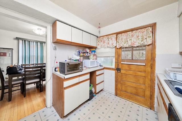 429 Geneva Ave, Bellwood, IL 60104 - kitchen with a toaster, light countertops, dishwasher, white microwave, and white cabinetry