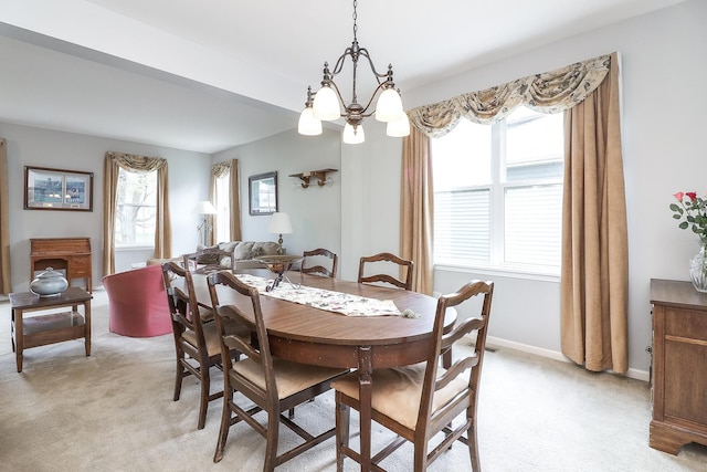 dining room featuring baseboards, a notable chandelier, and light carpet