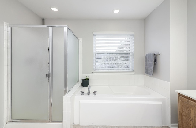 bathroom with vanity, a shower stall, a garden tub, and recessed lighting