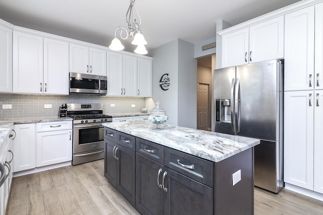 kitchen with light wood-style flooring, white cabinets, and stainless steel appliances