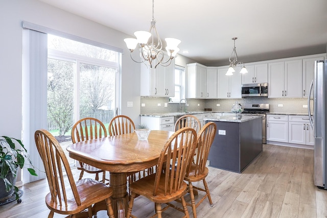 dining space featuring a chandelier and light wood-type flooring