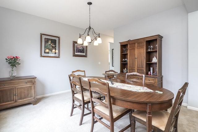 dining room with an inviting chandelier, baseboards, and light carpet