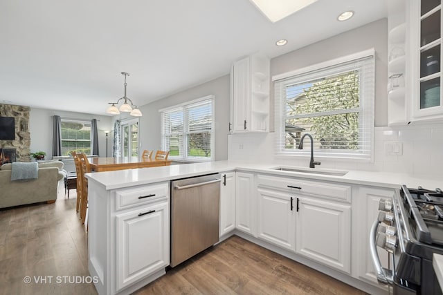 kitchen featuring a sink, white cabinetry, a peninsula, and stainless steel appliances