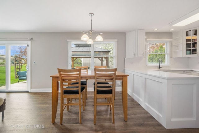 dining space with an inviting chandelier, recessed lighting, dark wood finished floors, and baseboards