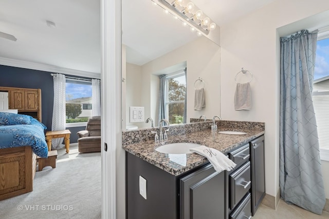 bathroom featuring double vanity, a sink, and baseboards