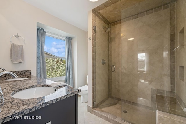 bathroom featuring vanity, tile patterned flooring, a stall shower, and toilet