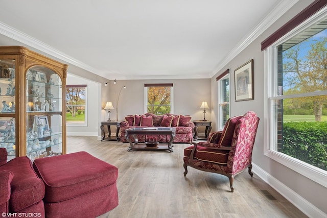 living room featuring baseboards, visible vents, ornamental molding, and wood finished floors
