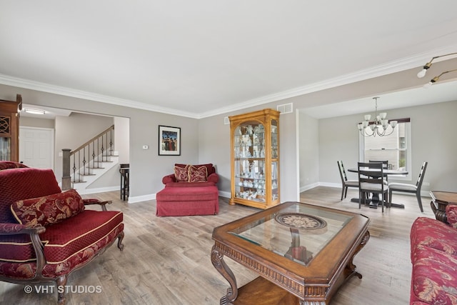 living room featuring a notable chandelier, light wood-type flooring, visible vents, ornamental molding, and stairway