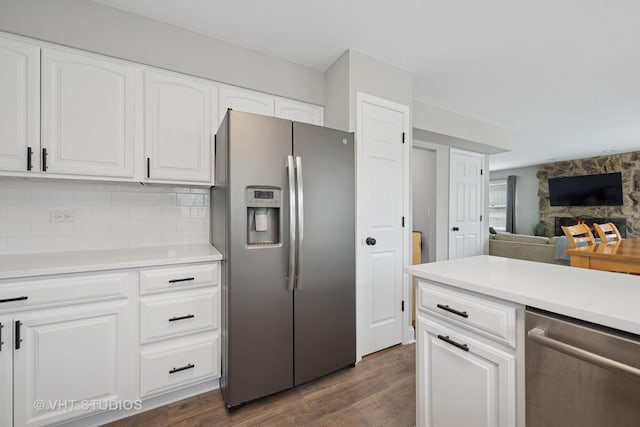 kitchen featuring dark wood-style flooring, a fireplace, light countertops, white cabinetry, and appliances with stainless steel finishes