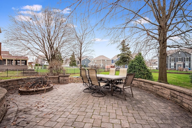 view of patio featuring fence, outdoor dining space, and a residential view