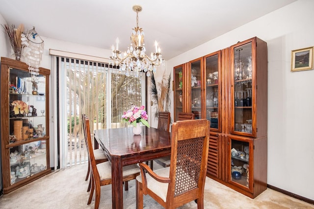 dining room with baseboards, light carpet, and an inviting chandelier