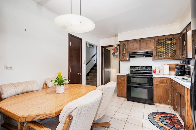kitchen with black range with electric cooktop, under cabinet range hood, light countertops, and light tile patterned floors