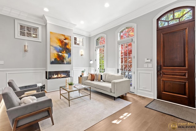 816 W Lill Ave, Chicago, IL 60614 - living area featuring a decorative wall, a glass covered fireplace, wood finished floors, ornamental molding, and recessed lighting