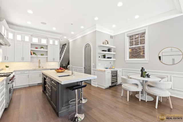 816 W Lill Ave, Chicago, IL 60614 - kitchen featuring beverage cooler, open shelves, white cabinetry, stainless steel range, and recessed lighting