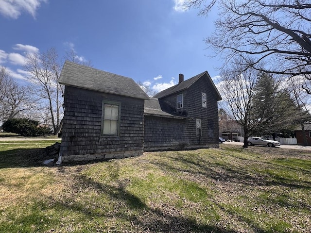 view of side of home featuring a lawn and a chimney