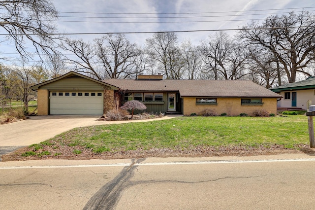 ranch-style house with concrete driveway, a chimney, an attached garage, a front yard, and brick siding