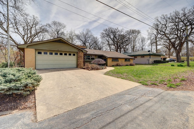 ranch-style home with brick siding, an attached garage, a front yard, and concrete driveway