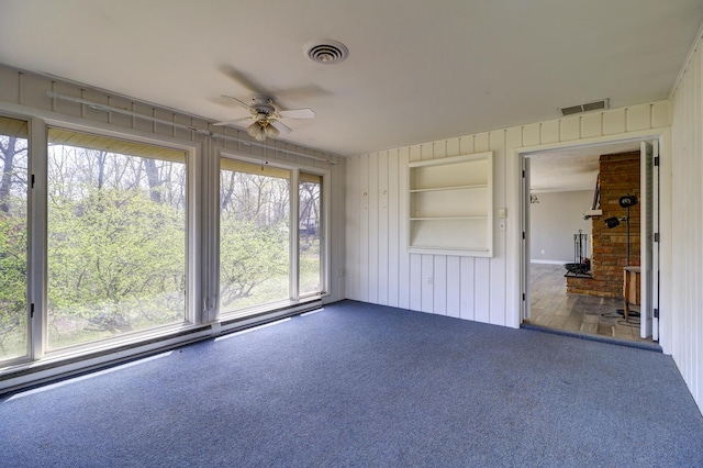 unfurnished sunroom featuring visible vents and ceiling fan