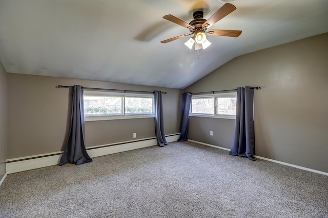 carpeted empty room featuring vaulted ceiling, baseboards, and a ceiling fan