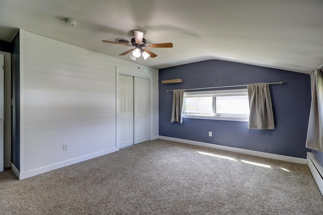 carpeted empty room featuring a baseboard heating unit, lofted ceiling, a ceiling fan, and baseboards