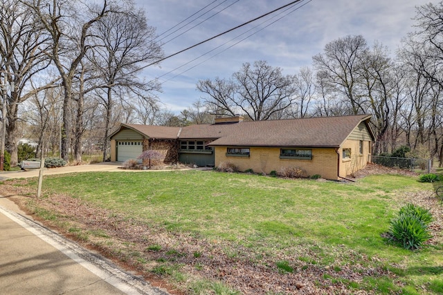 single story home featuring brick siding, concrete driveway, a front lawn, and fence