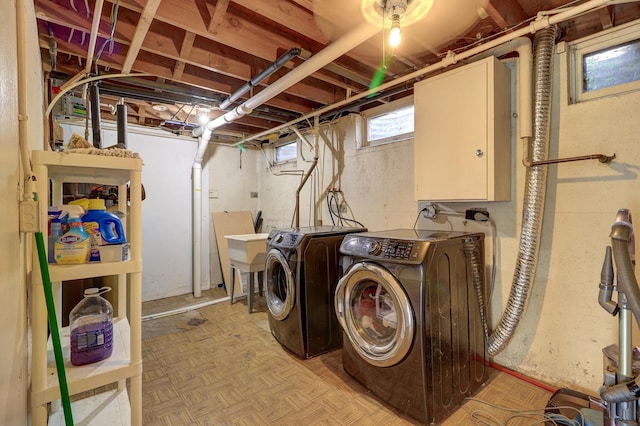 washroom featuring washing machine and dryer, cabinet space, and a sink
