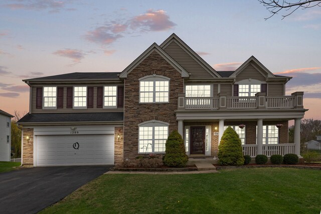 1289 Mallard Ln, Hoffman Estates, IL 60192 - view of front of home featuring a balcony, aphalt driveway, a porch, a yard, and a garage