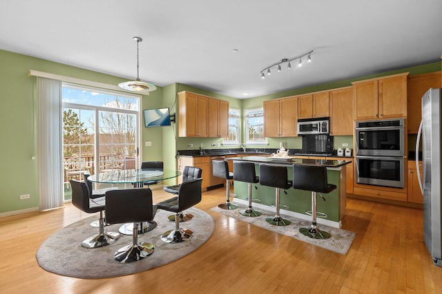 1289 Mallard Ln, Hoffman Estates, IL 60192 - kitchen featuring dark countertops, light wood-style floors, stainless steel appliances, baseboards, and a center island