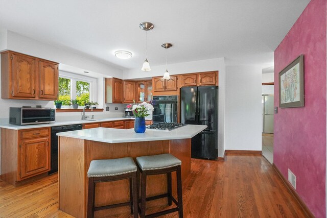 2756 Fox River Ln, Naperville, IL 60565 - kitchen featuring black appliances, a sink, light countertops, and brown cabinetry